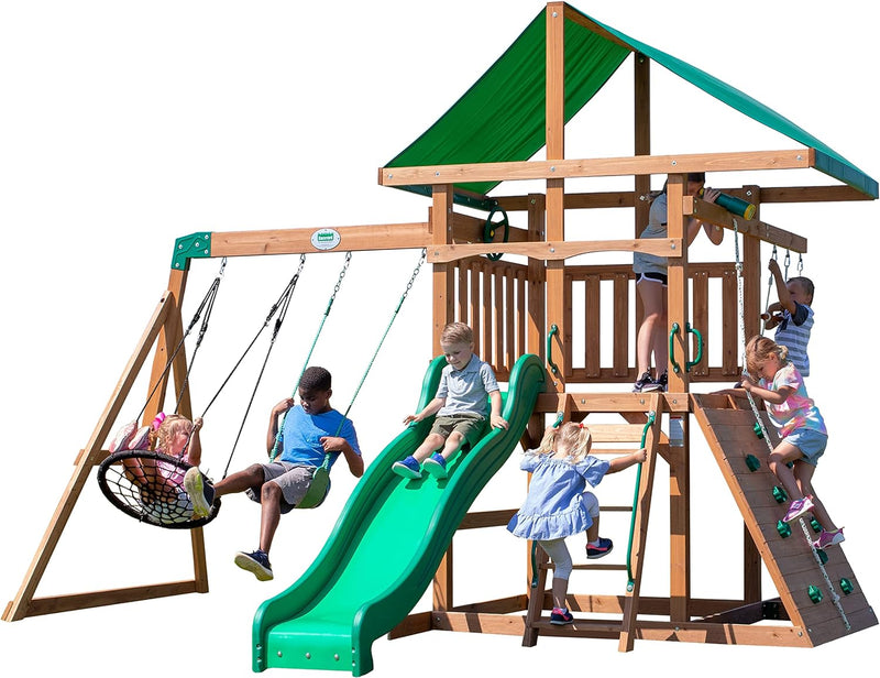 A complete set of wooden mountain-style swings, equipped with a colorful canvas sunshade, a wave slide, a rope swing, a net swing, and a rock wall with climbing ropes and ladders. V9871